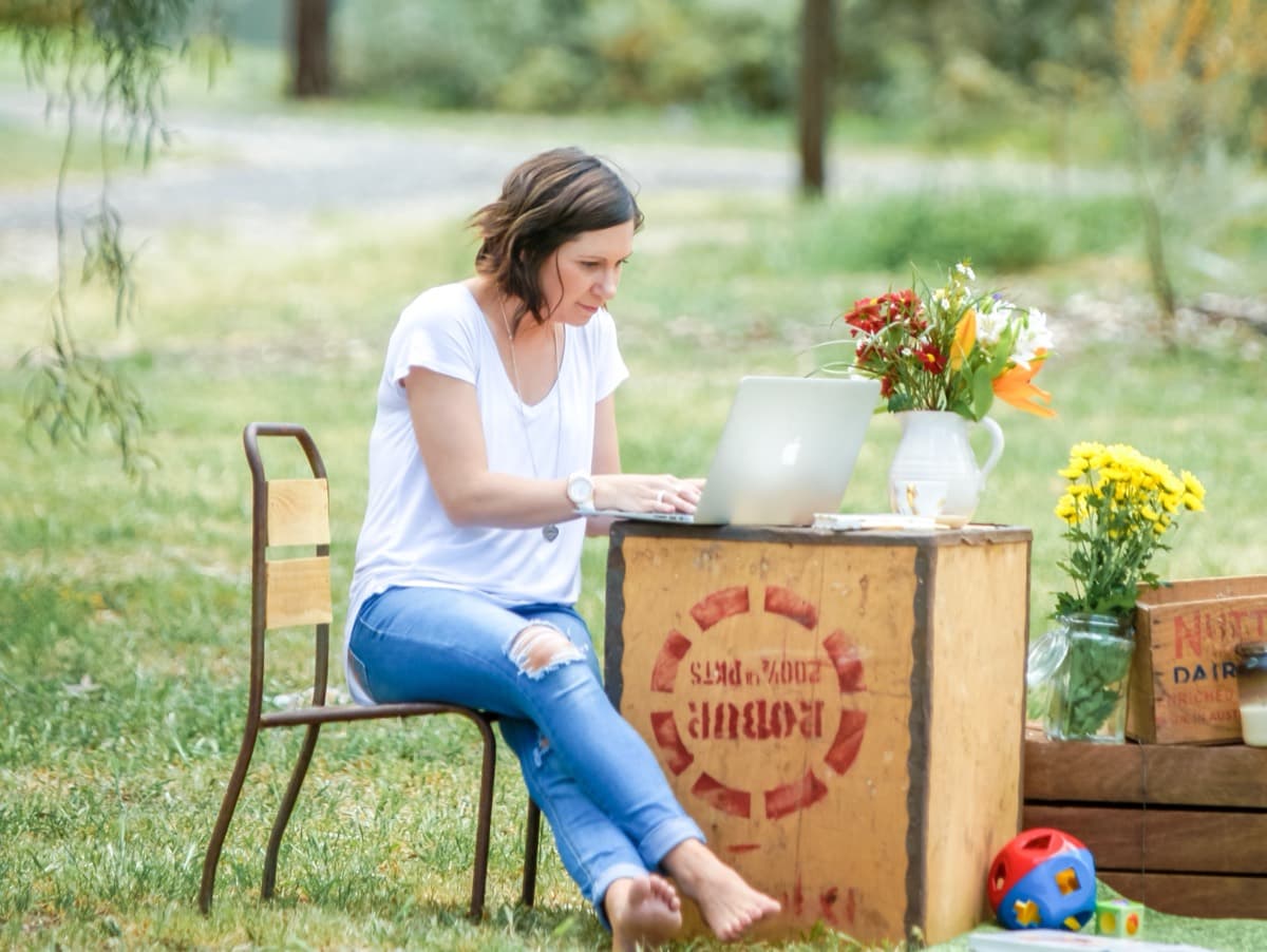 Steph working at a makeshift desk in a country paddock