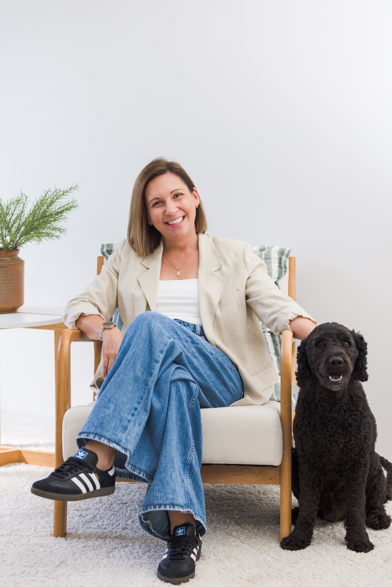 Steph Bartram, founder of Steph Does Systems, relaxed in an armchair with her dog beside her